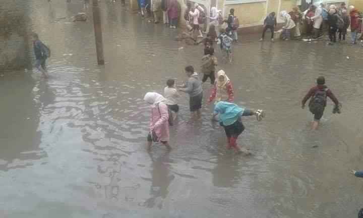 طلاب مدرسة قرية البنائين يلعبون في مياه الأمطار.. صور