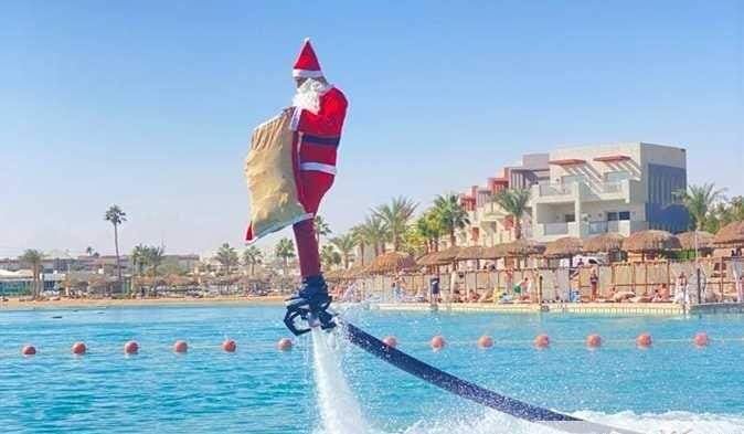 بالصور::الفلاي بورد» بملابس بابا نويل يوزع الهدايا على نزلاء فنادق الغردقة